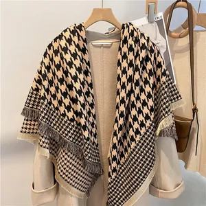 Detailed close-up of houndstooth scarf with elegant yellow and black fringe tassels