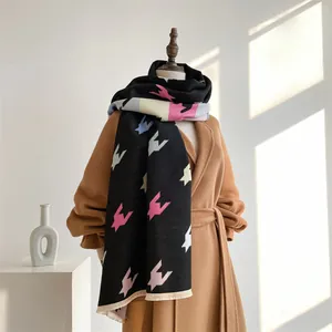 Detailansicht eines Winter-Schals mit farbigem Hahnentritt-Muster auf Wollmantel