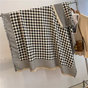 Detailed close-up of classic black and white houndstooth shawl with elegant fringe edges