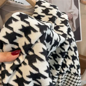 Detailed close-up of thick black and white houndstooth cashmere-like scarf fabric