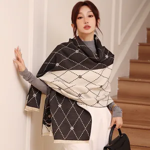 Detail of camellia floral pattern and plaid fringe on oversized cashmere-feel shawl