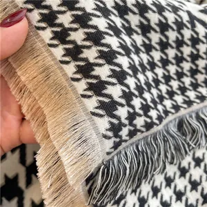 Close-up of black and white houndstooth scarf showing weave texture and tassel detail