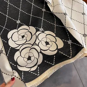Close-up of thick camellia flower pattern shawl with fringe edges and diamond grid