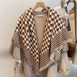 Elegant brown and beige houndstooth scarf with tassels styled over a matching wool coat