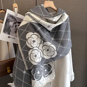Macro detail of camellia pattern and thick grey knit texture on cashmere-like scarf