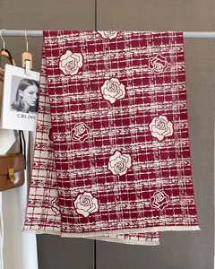 Detail of red and cream plaid scarf featuring realistic rose floral patterns and fringe