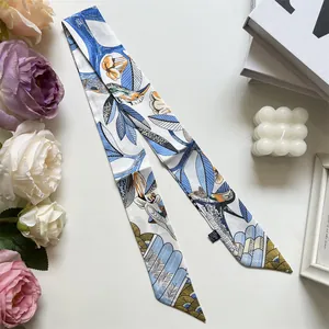 Detalle de pañuelo de seda con pájaros azules y flores con elegantes objetos decorativos
