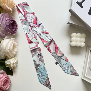 Detalle de un pañuelo Twilly azul claro con estampado floral y pájaros con etiqueta