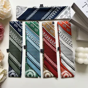 Flat lay of colorful paisley printed silk twilly scarves with decorative gift box