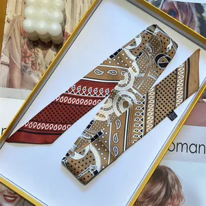 Macro detail of wine red silk twilly scarf with paisley patterns in premium gift box
