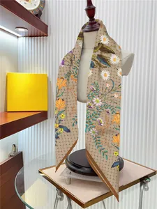 Vue détaillée d'un foulard en soie beige avec motifs de marguerites et de lys sur support
