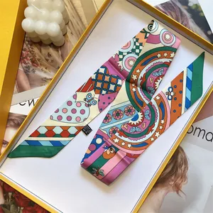 Close-up of colorful twilly scarf with 100% polyester label in orange gift box
