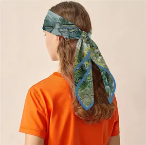Détail d'un foulard en soie style peinture porté en bandeau sur un modèle