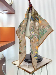 Détail d'un foulard en soie avec motifs de marguerites et de lys et ourlet fin sur mannequin