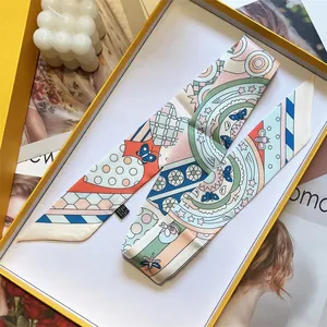 Detailed view of printed twilly silk scarf with butterfly pattern in yellow gift box