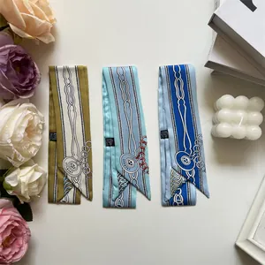 Détail de foulards twilly à motifs de chaînes, étiquettes de lavage et fleurs