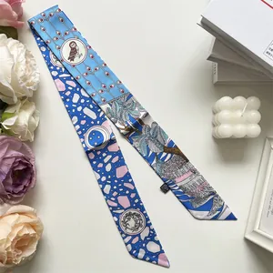 Detail eines blauen bedruckten Seidentwillys mit Eulen- und Sternmustern und Palmenblättern
