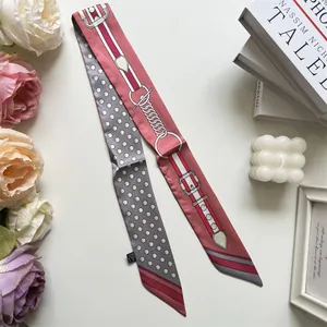 Detail of pink and grey twilly scarf with equestrian horse bit and polka dot patterns