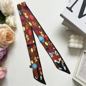 Détail d'un foulard fin en soie marron avec imprimé renard enroulé sur une anse