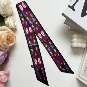 Détail d'un foulard étroit bordeaux avec motifs de marguerites et dessin de chat noir