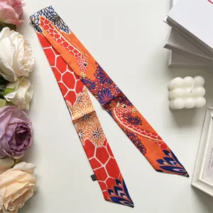 Detailed close-up of a long skinny scarf with giraffe print and orange floral patterns