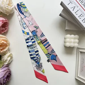 Detail van een kleurrijke zijden twilly sjaal met zeilbootprint en bloemendecoratie