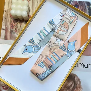 Detail van de zijden sjaal met vogelpatroon in een stijlvolle cadeauverpakking