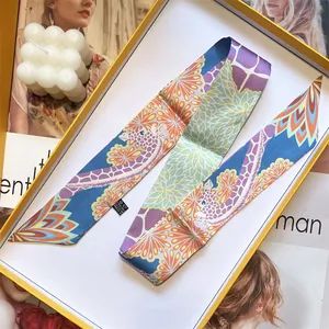 Detailed view of long colorful giraffe print twilly scarf folded in a gift box
