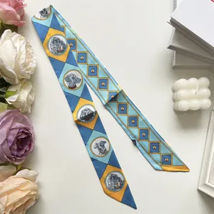 Détail du foulard twilly étroit avec motifs en losange bleu jaune et illustrations de chiens