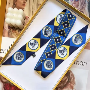 Détail macro d'un foulard étroit à motifs géométriques dans une boîte cadeau jaune