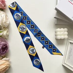 Détail d'un foulard twilly bleu et jaune avec portraits de chiens et losanges
