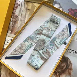 Zijden sjaal met tropische apenprint in S-vorm gepresenteerd in een gele geschenkdoos