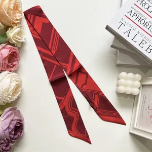 Dettaglio di foulard in seta rosso marrone con motivi geometrici per manici di borse