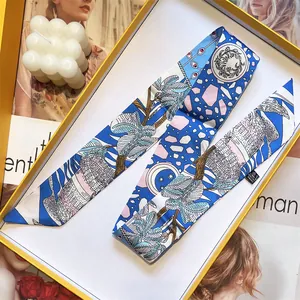 Silk-like long ribbon scarf with floral print and gift box on a stylish magazine background