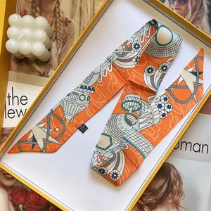 Écharpe étroite orange en soie à motifs géométriques avec son coffret cadeau jaune