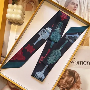Detail van een marineblauwe zijden sjaal met klassieke patronen in geschenkdoos