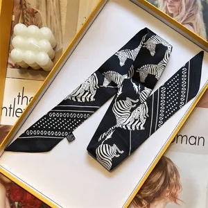 Detail of zebra pattern twilly silk scarf with paisley motifs in elegant gift box