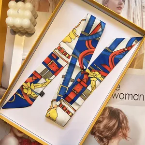Elegantes Seidentuch mit Blumenmuster ordentlich gefaltet in einer orangefarbenen Box