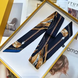 Blue silk scarf with gold chain print in an elegant yellow gift box on a fashion magazine