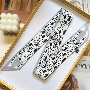 Detail of grey and white dalmatian dog print twilly scarf with elegant polka dot pattern