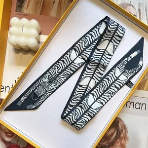 Detail of a zebra print twilly scarf made of 100% polyester inside a yellow gift box