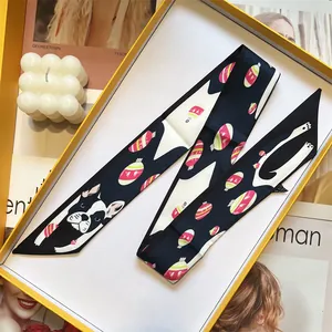 Detail of cute French Bulldog pattern twilly scarf inside a bright yellow gift box