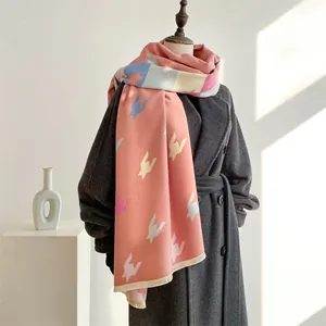 Detail eines weichen rosa Schals mit Hahnentrittmuster und Fransen an einer Schaufensterpuppe
