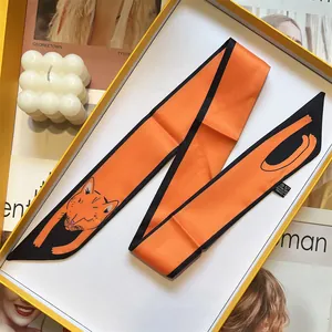 Detail of vibrant orange twilly silk scarf with cute orange cat illustration and black edges