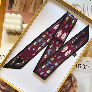 Detail of burgundy floral silk scarf with cat patterns inside a yellow gift box