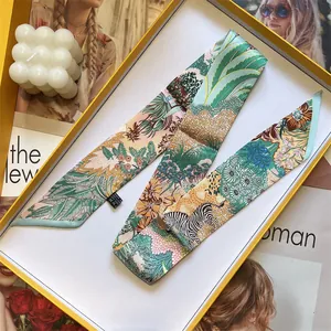 Detail of floral zebra print silk twilly scarf with wash label in luxury yellow box