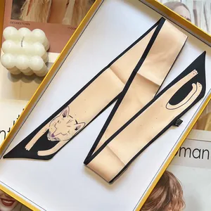 Detailed close-up of a 100% silk twilly scarf with cute cat illustration in a luxury gift box