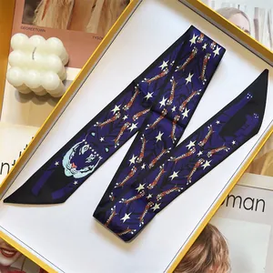 Close-up of a blue tiger print silk twilly scarf folded inside a premium yellow gift box
