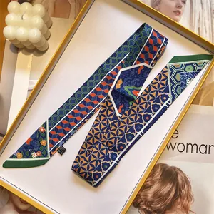 Detail of printed silk twilly scarf with geometric patterns in a yellow gift box
