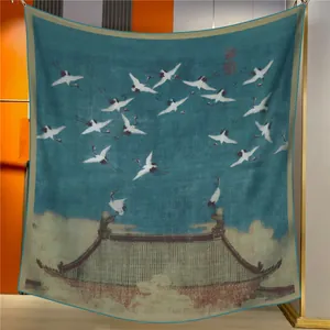 Détail d'une écharpe en soie bleue avec motif de grue dans une pièce moderne
